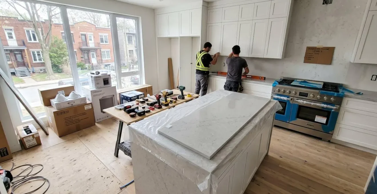 Chantier de rénovation haut de gamme en cours dans une cuisine montréalaise, avec comptoirs en quartz et armoires sur mesure en installation